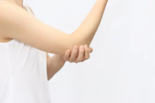 肘を押さえる女性イメージ